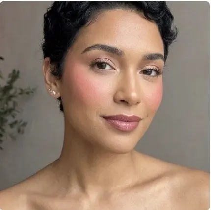 Joues rosées et lèvres roses, cheveux courts bouclés