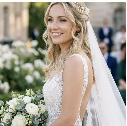 Mariée blonde avec voile et accessoire de cheveux, bouquet de roses blanches